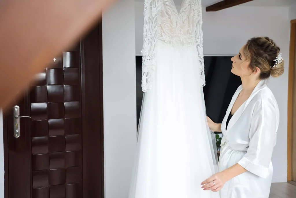 Fotograf Kamerzysta Weselny Lubuskim Przygotowania, Kinga spogląda na suknię ślubną (2)