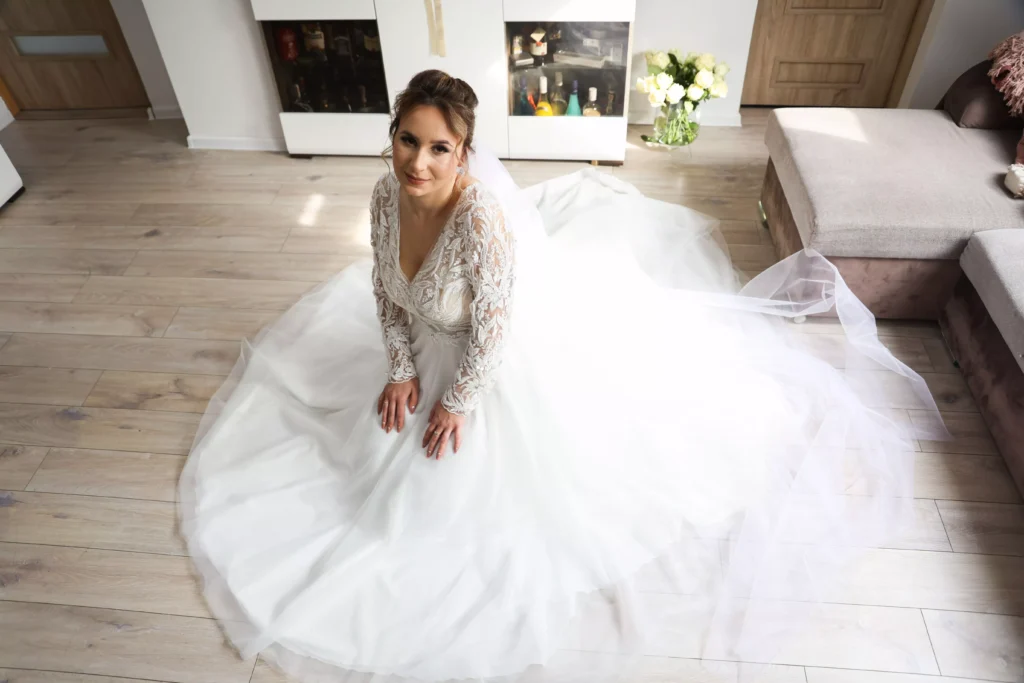 Fotograf Kamerzysta Weselny Lubuskim Kinga klęcząca na ziemi w pięknej suki ślubnej
